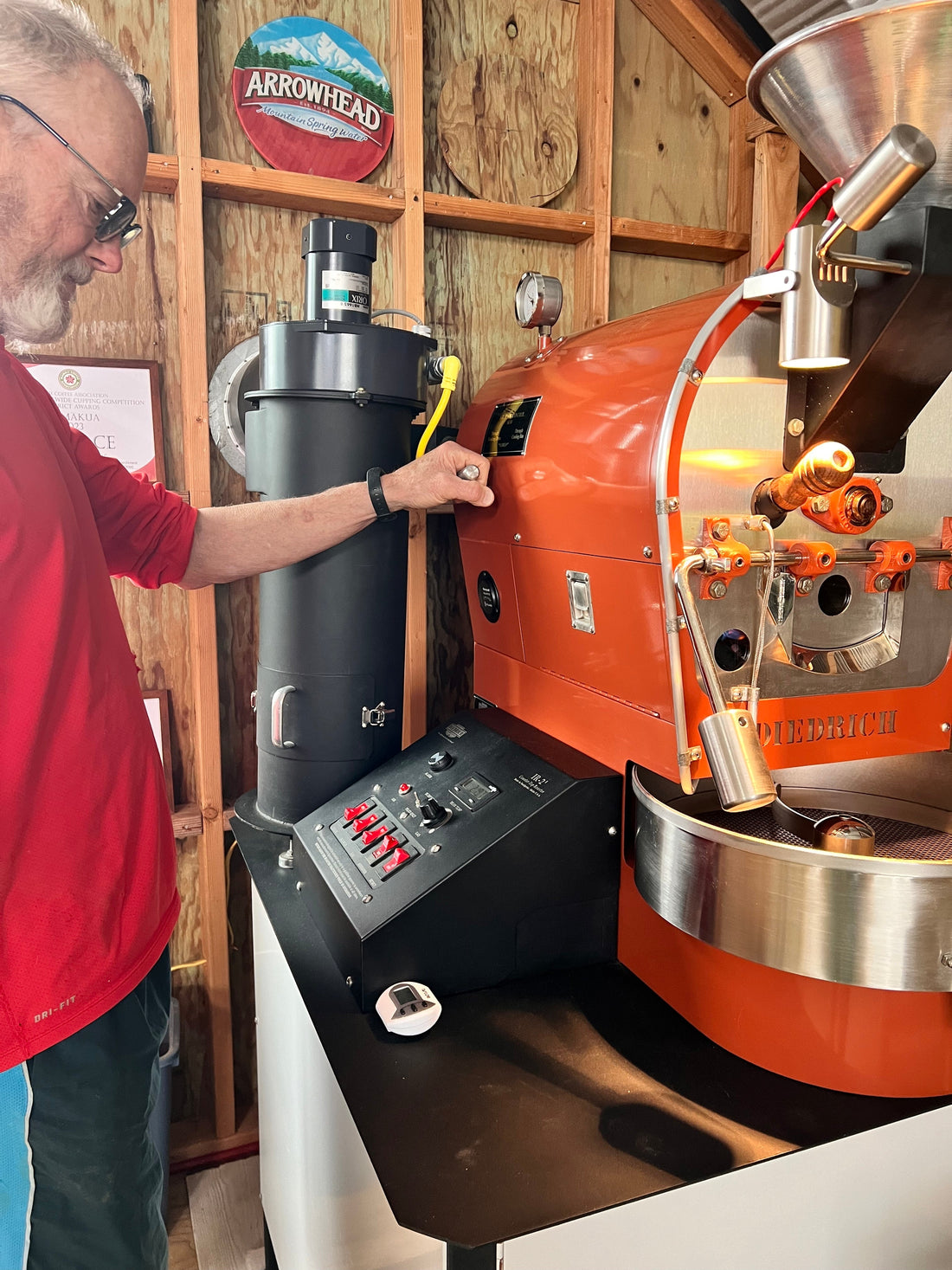 Manu overseeing small coffee roaster machine